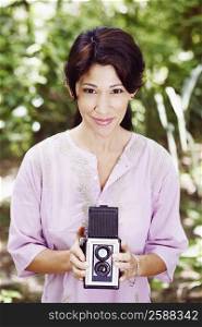 Portrait of a mature woman holding a camera