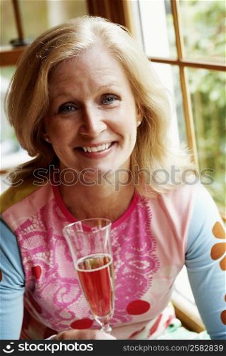 Portrait of a mature woman holding a champagne flute and smiling