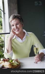Portrait of a mature woman holding a champagne flute and smiling