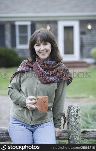 Portrait of a mature woman holding a coffee cup and smiling