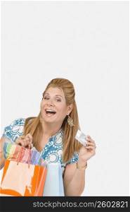 Portrait of a mature woman holding a credit card and shopping bags