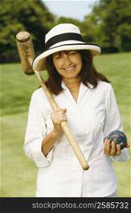 Portrait of a mature woman holding a croquet mallet and a ball