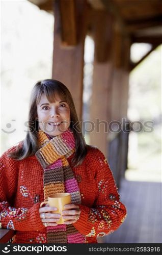 Portrait of a mature woman holding a cup and smiling