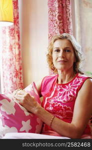 Portrait of a mature woman holding a cushion