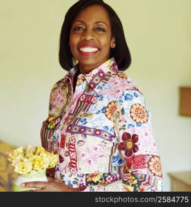 Portrait of a mature woman holding a flower pot and smiling