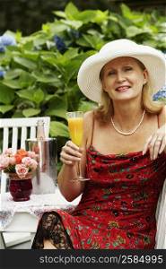 Portrait of a mature woman holding a glass of juice