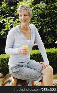 Portrait of a mature woman holding a glass of orange juice