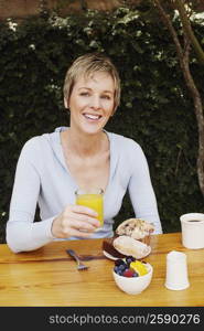 Portrait of a mature woman holding a glass of orange juice