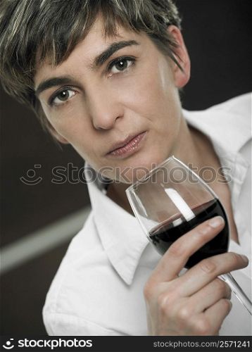 Portrait of a mature woman holding a glass of red wine