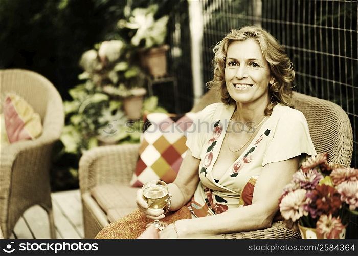 Portrait of a mature woman holding a glass of wine and smiling