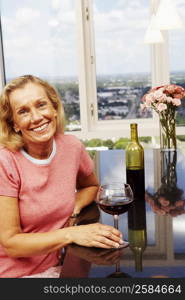 Portrait of a mature woman holding a glass of wine and smiling