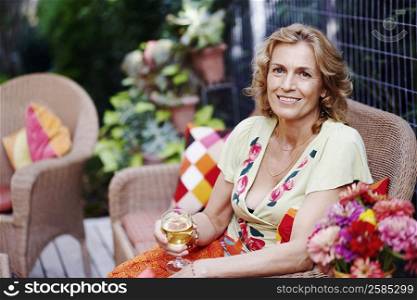 Portrait of a mature woman holding a glass of wine and smiling