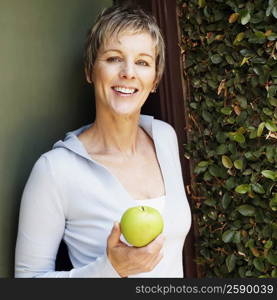 Portrait of a mature woman holding a granny smith apple