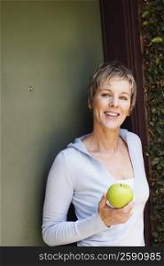 Portrait of a mature woman holding a granny smith apple