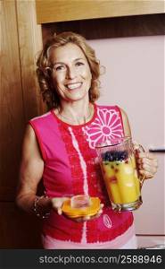 Portrait of a mature woman holding a jug of mango shake