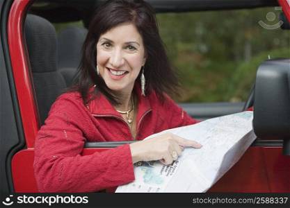 Portrait of a mature woman holding a map and smiling
