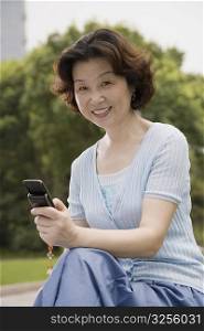 Portrait of a mature woman holding a mobile phone and smiling