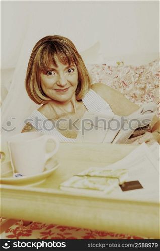 Portrait of a mature woman holding a newspaper and grinning