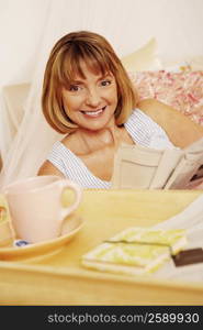 Portrait of a mature woman holding a newspaper and smiling