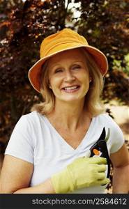 Portrait of a mature woman holding a pair of pruning shears and smiling