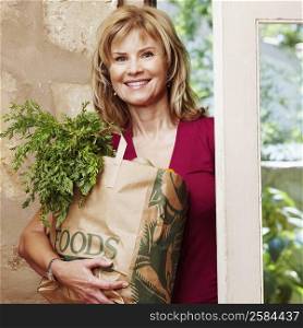 Portrait of a mature woman holding a shopping bag and smiling
