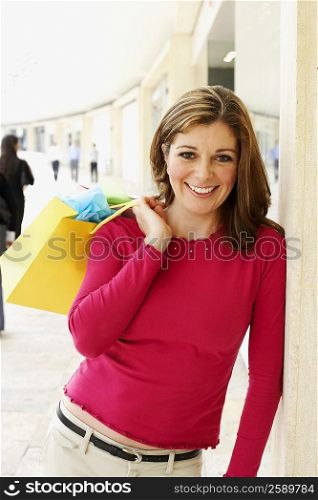 Portrait of a mature woman holding a shopping bag and smiling