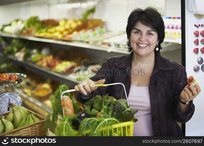 Portrait of a mature woman holding a shopping basket and smiling