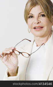 Portrait of a mature woman holding eyeglasses