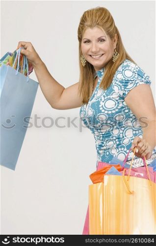 Portrait of a mature woman holding shopping bags and smiling