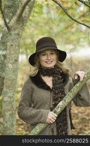 Portrait of a mature woman holding the branch of a tree and smiling