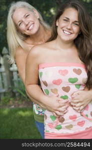 Portrait of a mature woman hugging her daughter from behind and smiling