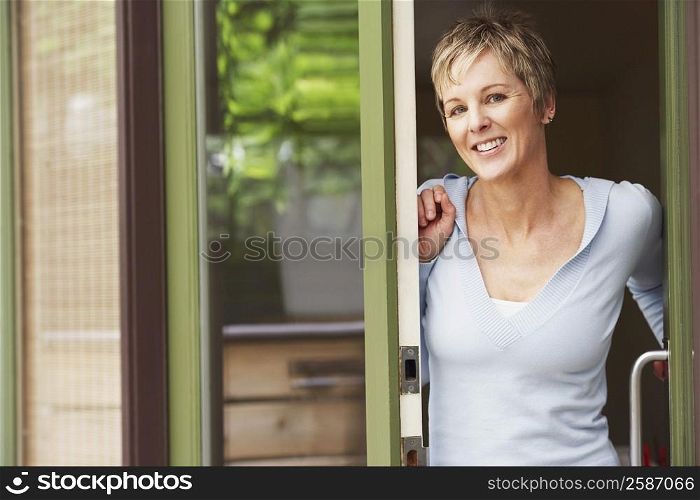 Portrait of a mature woman leaning against a door