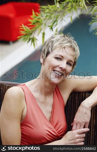 Portrait of a mature woman leaning against a fence and smiling