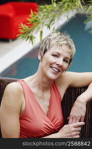 Portrait of a mature woman leaning against a fence and smiling