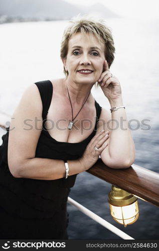 Portrait of a mature woman leaning against a railing and smiling