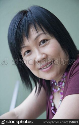 Portrait of a mature woman leaning against a railing and smiling