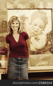 Portrait of a mature woman leaning against a table and smiling