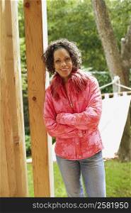 Portrait of a mature woman leaning against a wooden pole