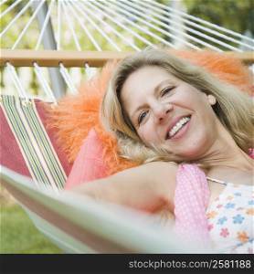 Portrait of a mature woman lying in a hammock and smiling