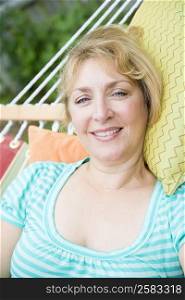 Portrait of a mature woman lying in a hammock and smiling