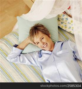 Portrait of a mature woman lying in bed and smiling