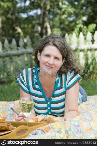 Portrait of a mature woman lying on a picnic blanket