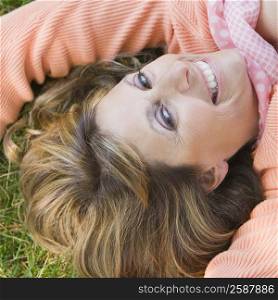 Portrait of a mature woman lying on grass and smiling