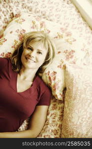 Portrait of a mature woman lying on the bed and smiling