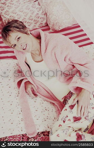 Portrait of a mature woman lying on the bed and smiling