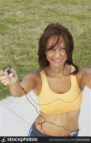 Portrait of a mature woman offering her ear bud and smiling, South Beach, Miami Beach, Florida, USA