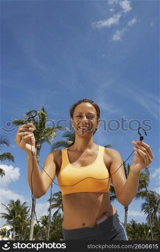 Portrait of a mature woman offering her ear bud, Miami beach, Florida, USA