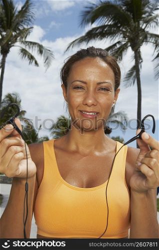 Portrait of a mature woman offering her ear bud, Miami beach, Florida, USA