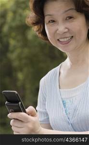 Portrait of a mature woman operating a mobile phone and smiling