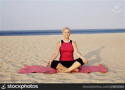 Portrait of a mature woman performing yoga on the beach